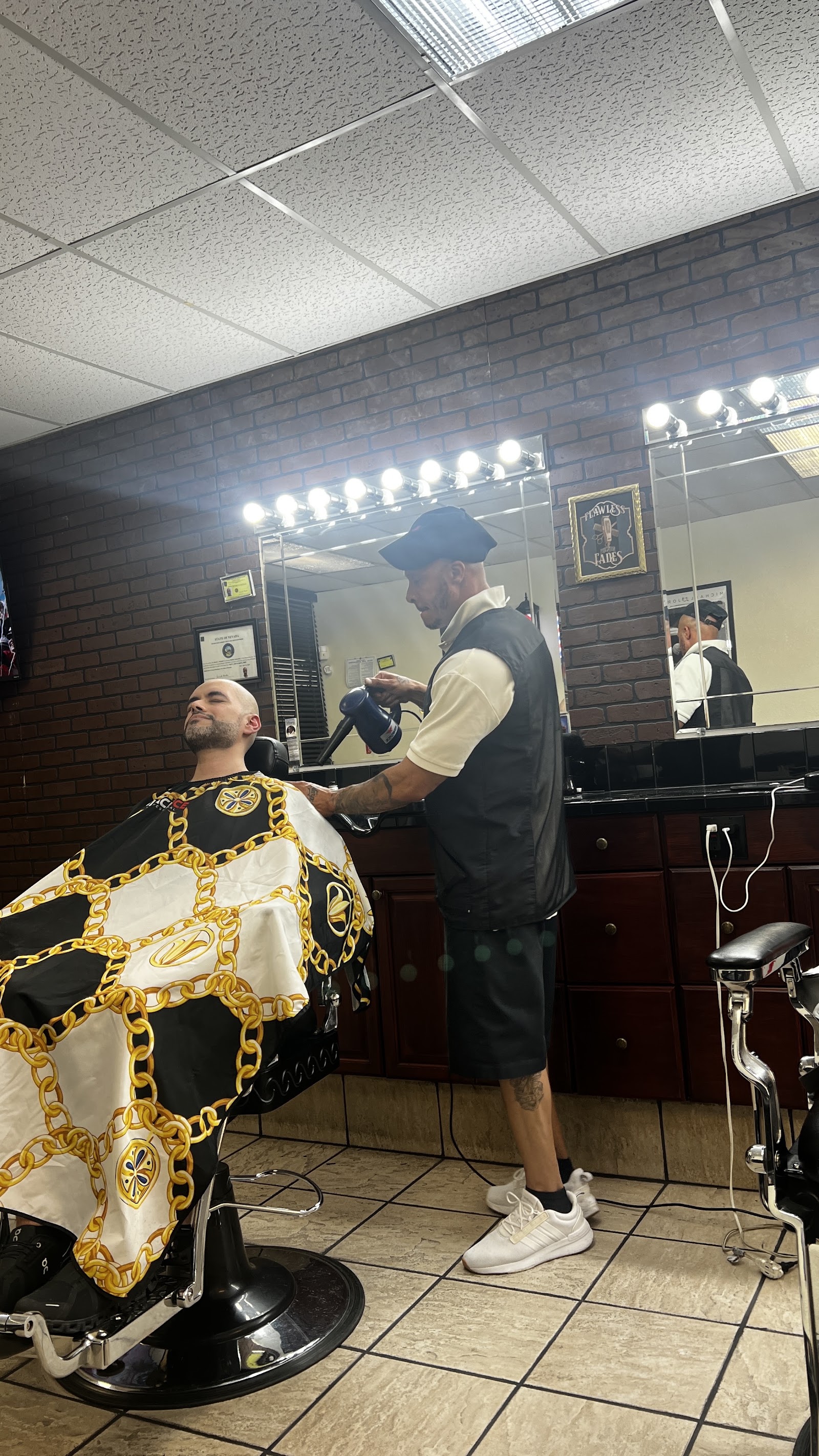 Barber blow-drying a client's hair in the shop