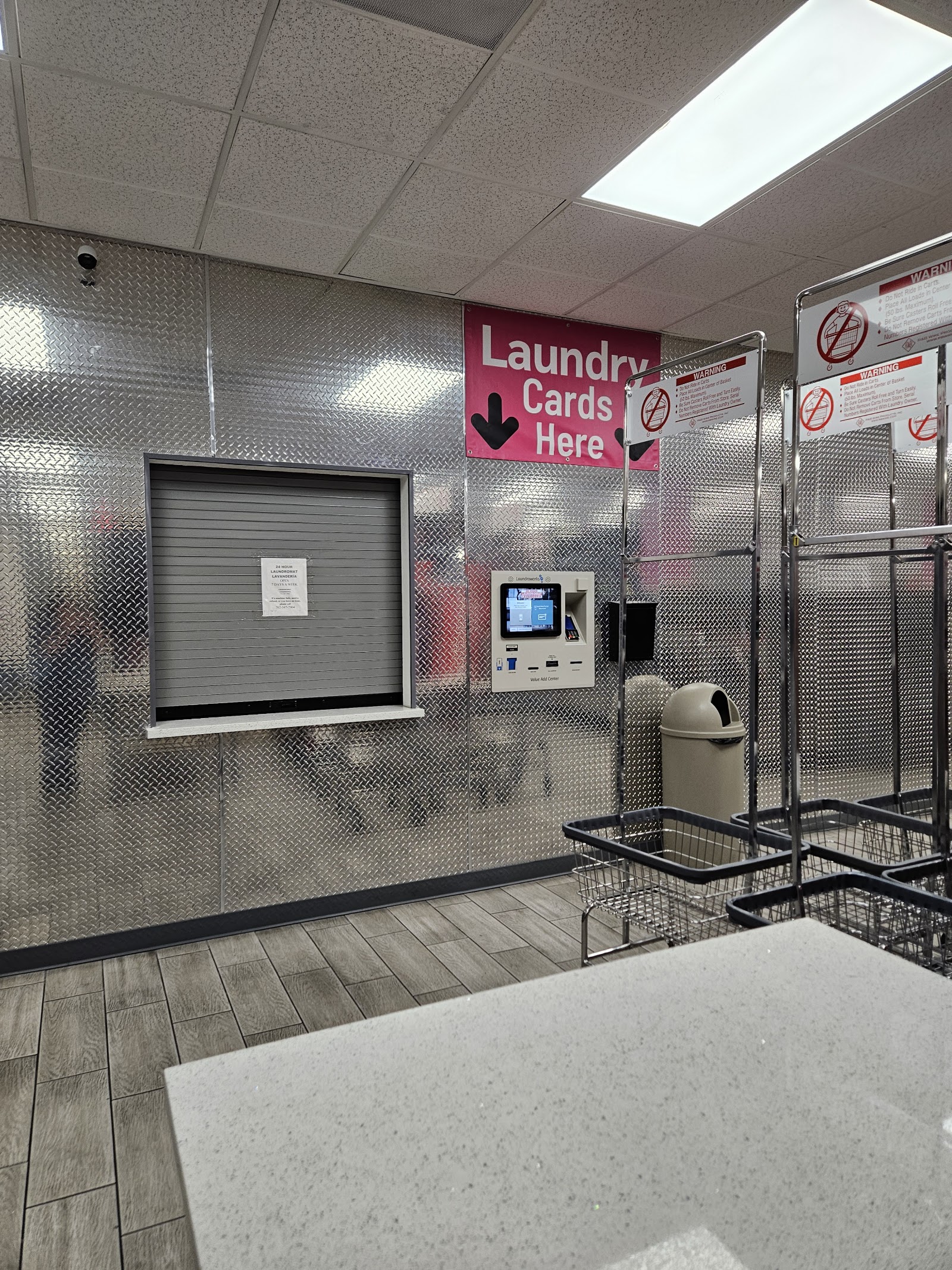 Interior with laundry card kiosk, carts, and Laundry Cards Here sign