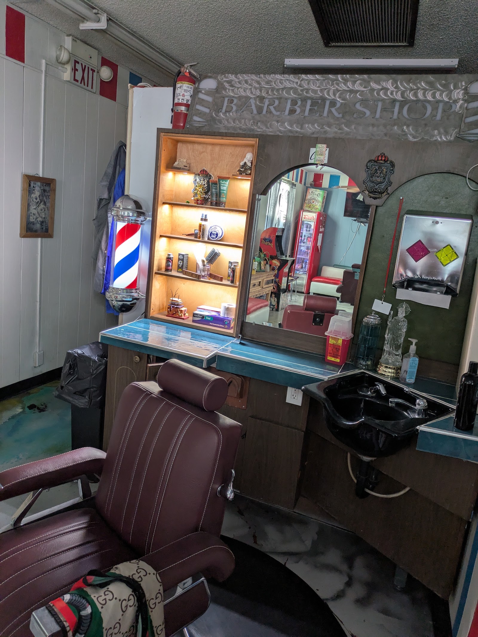 Barber station with vintage leather chair, barber pole, lit product shelf and mirror