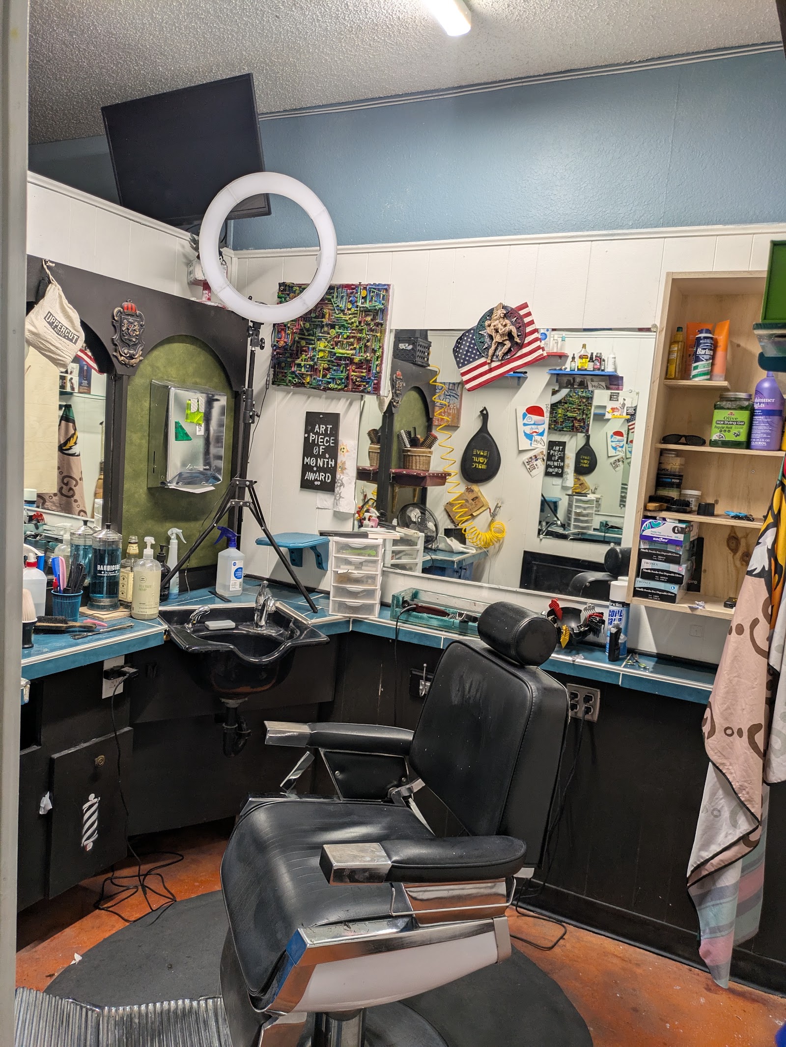 Barber chair with ring light, mirrors, American flag decor and product shelf