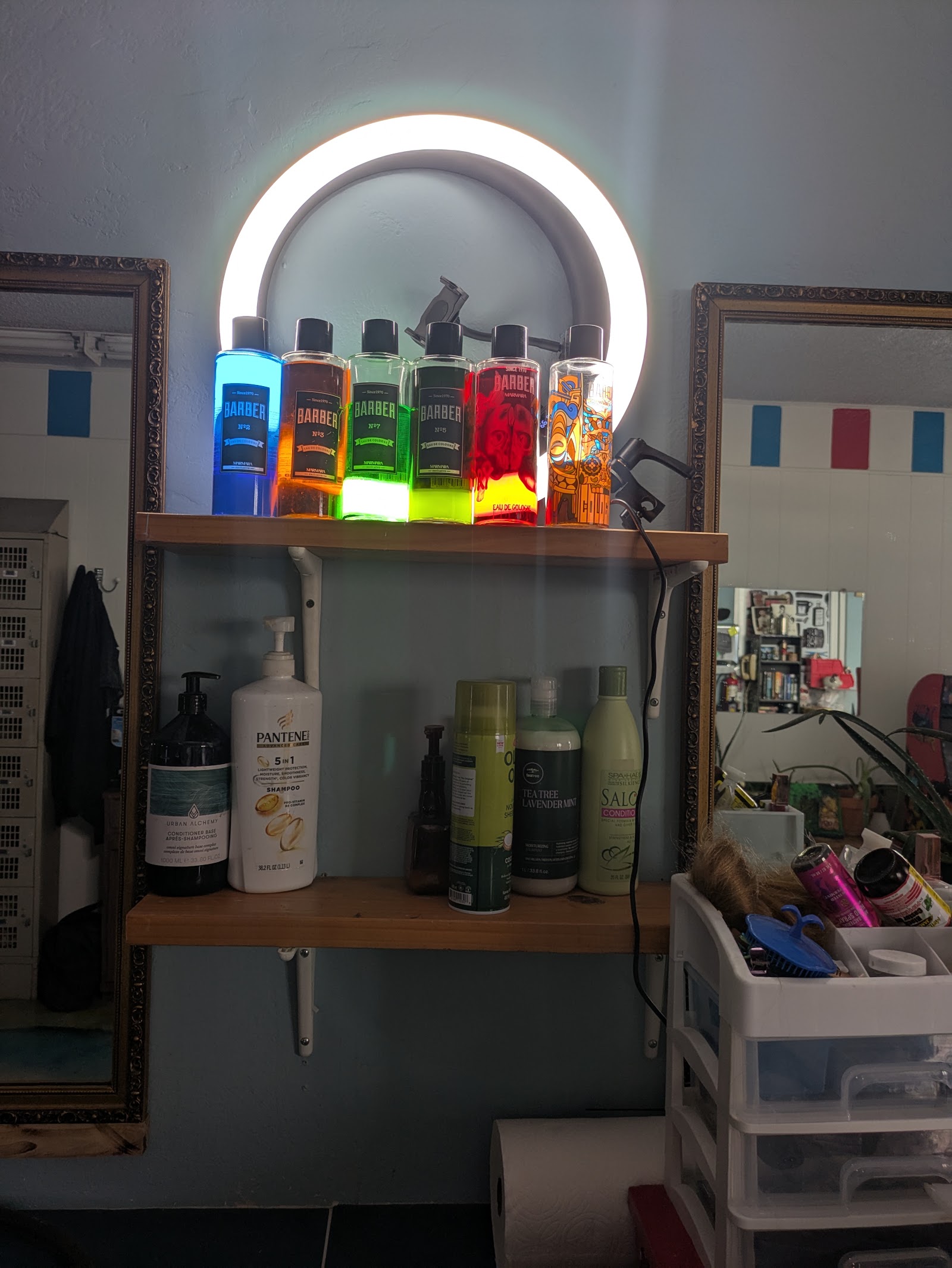 Colorful Marmara Barber cologne bottles backlit by ring light on shelf