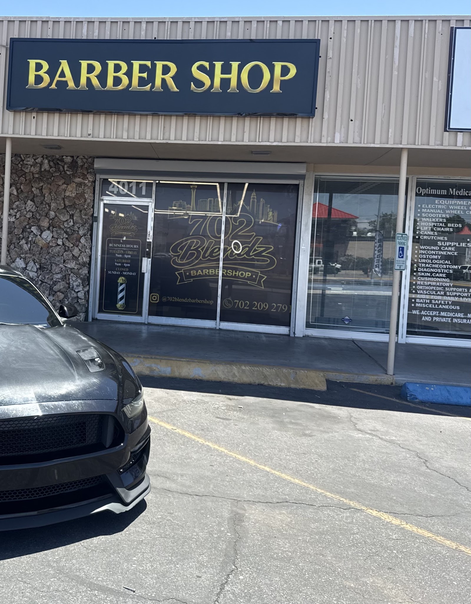 Exterior of 702 Blendz Barbershop with large BARBER SHOP sign and window logo