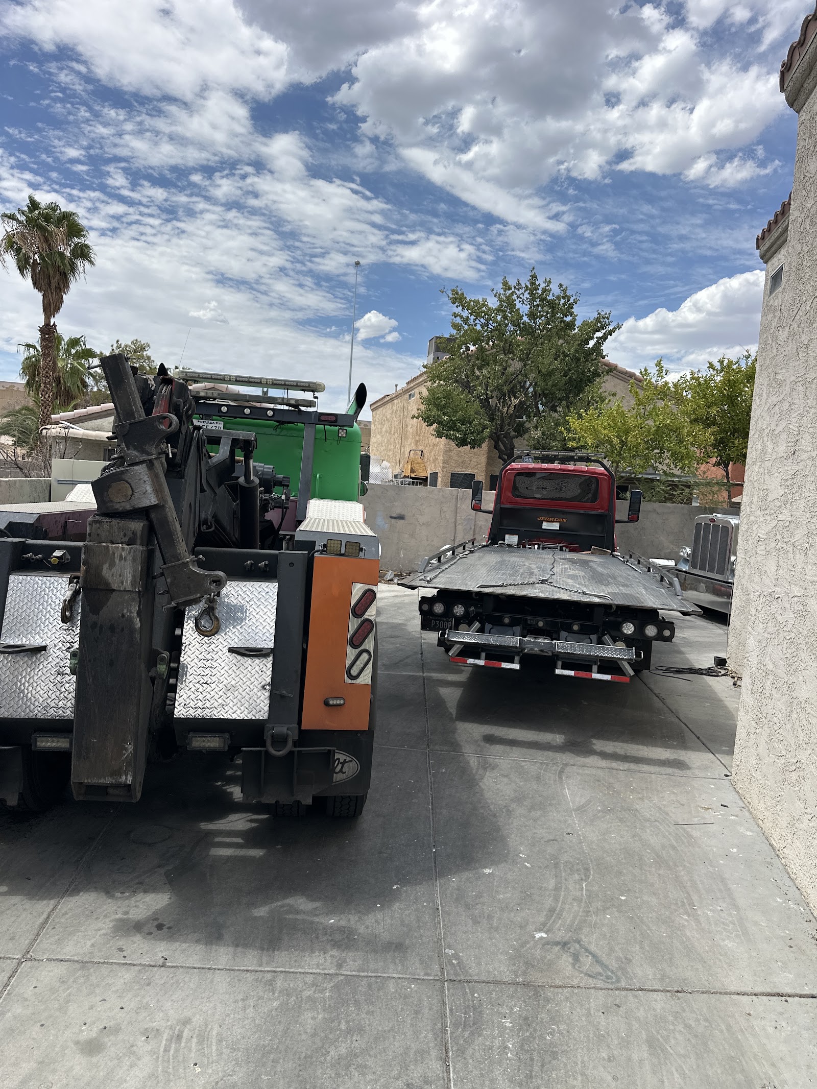 Heavy-duty wrecker and flatbed tow truck parked in a lot