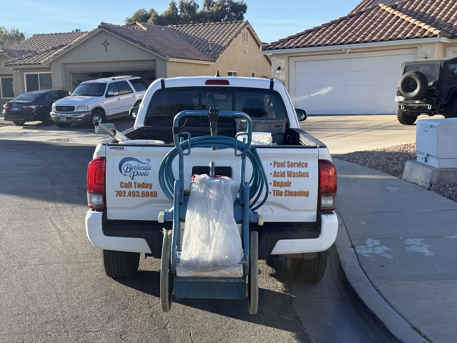Bethesda Pools white pickup truck with service equipment and branding decal