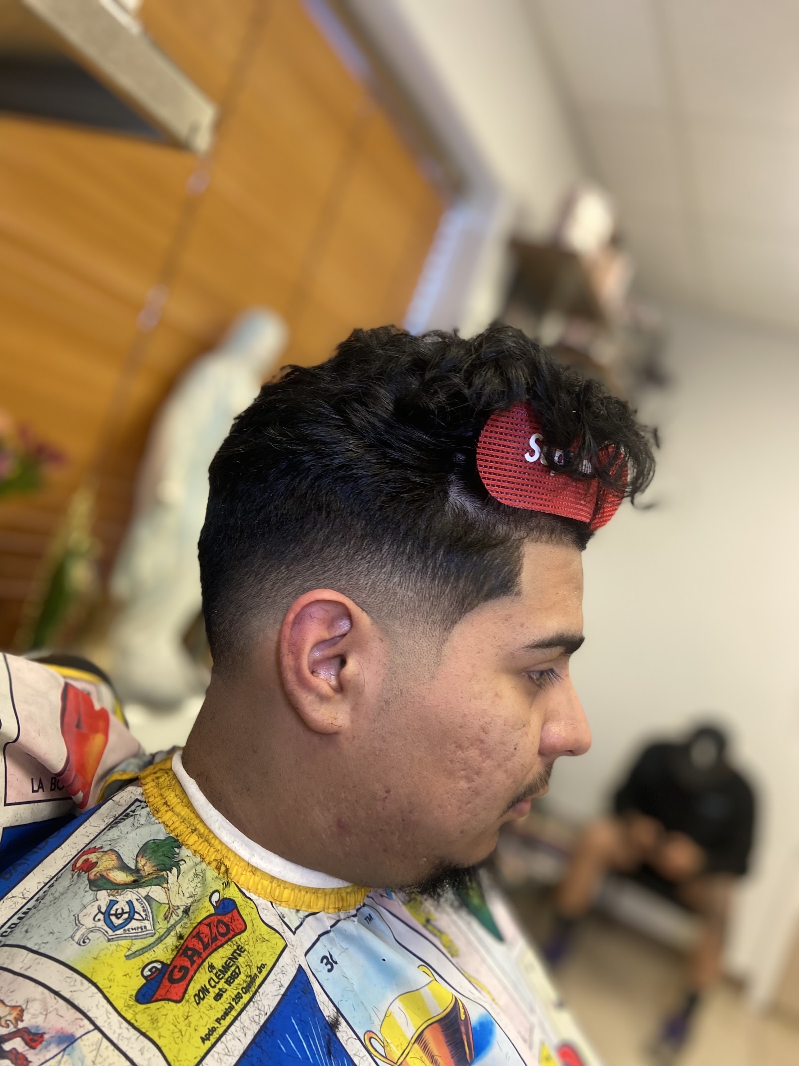 Side profile of a curly-top haircut with low fade and hairnet