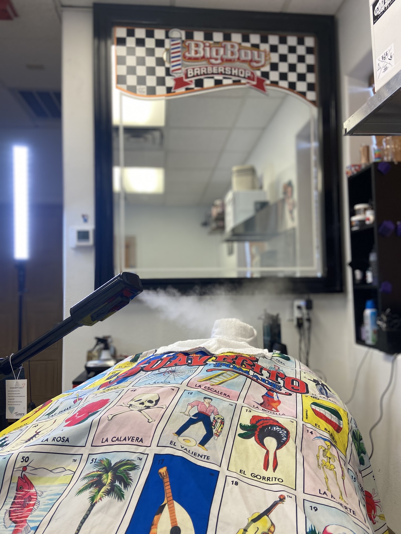 Barber station with mirror bearing Big Boy Barbershop logo and hot towel steam