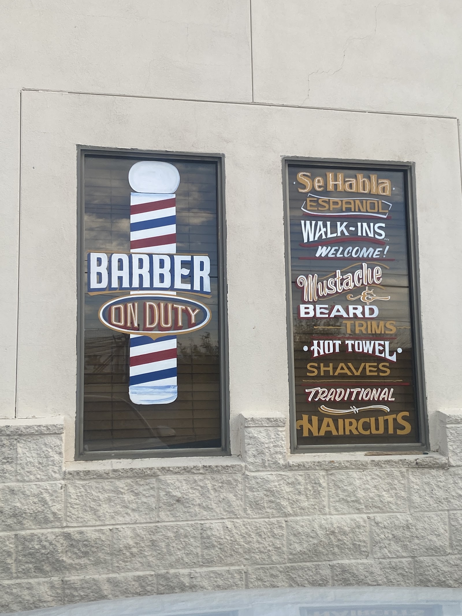 Painted barbershop windows: Barber On Duty and services list