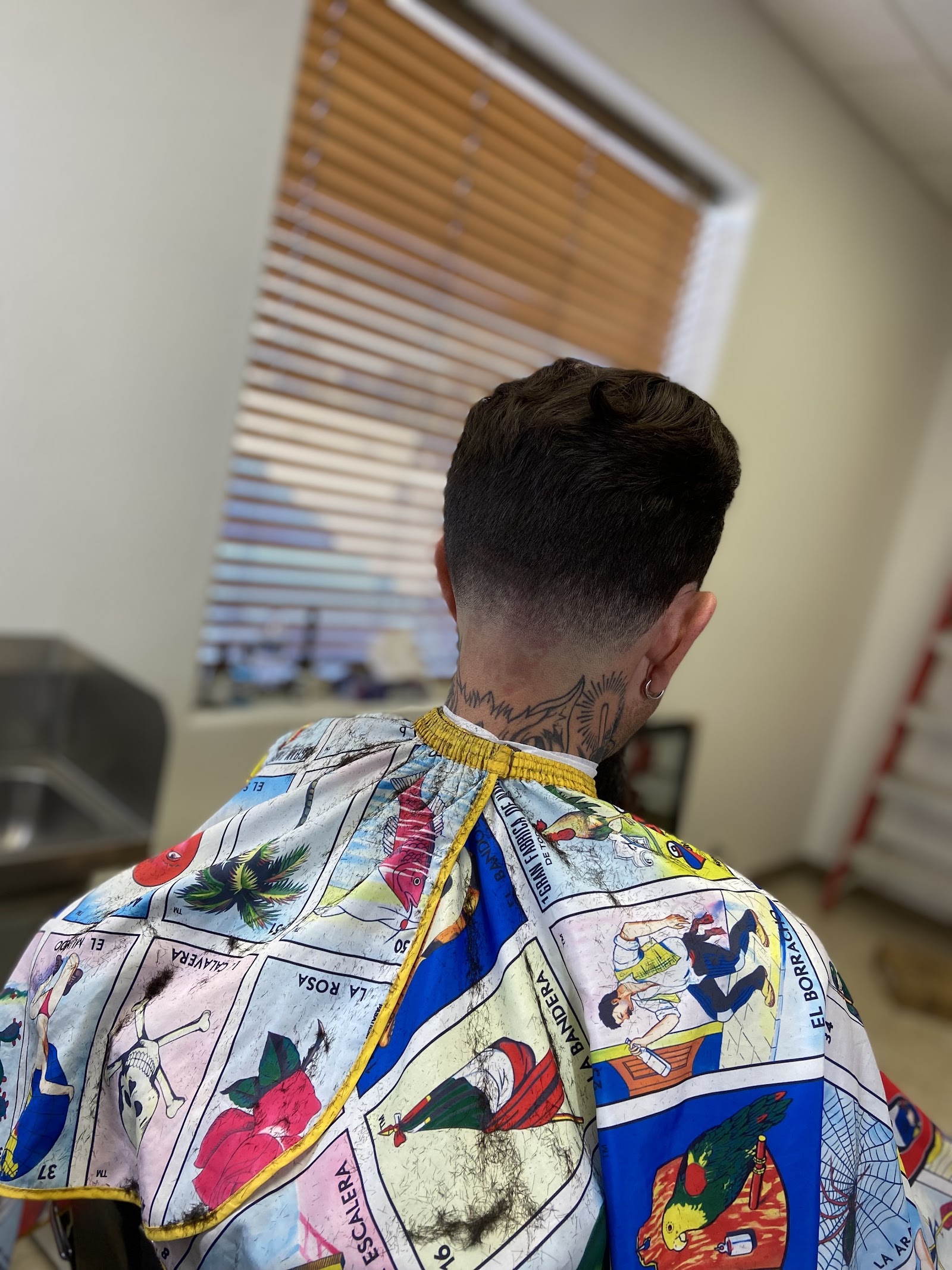 Back view of a men's mullet-style haircut with low fade