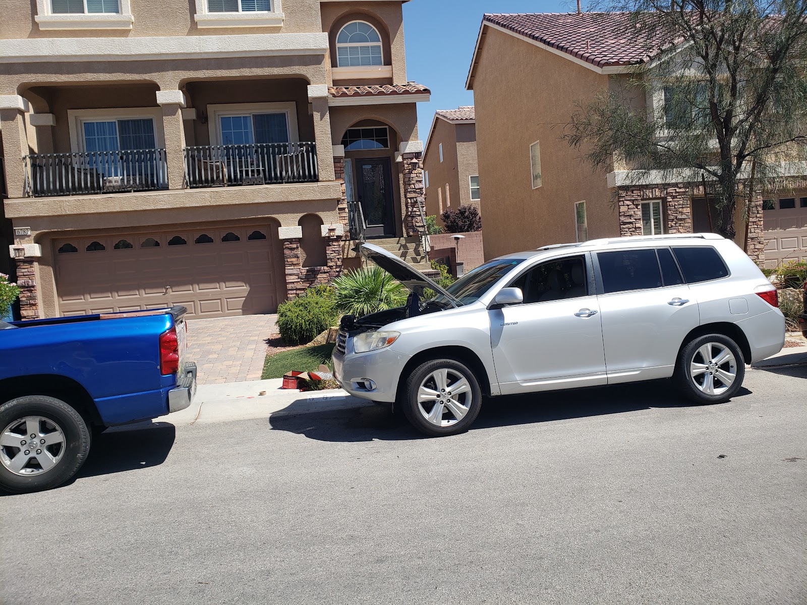 Silver Toyota Highlander with hood open parked curbside for mobile service