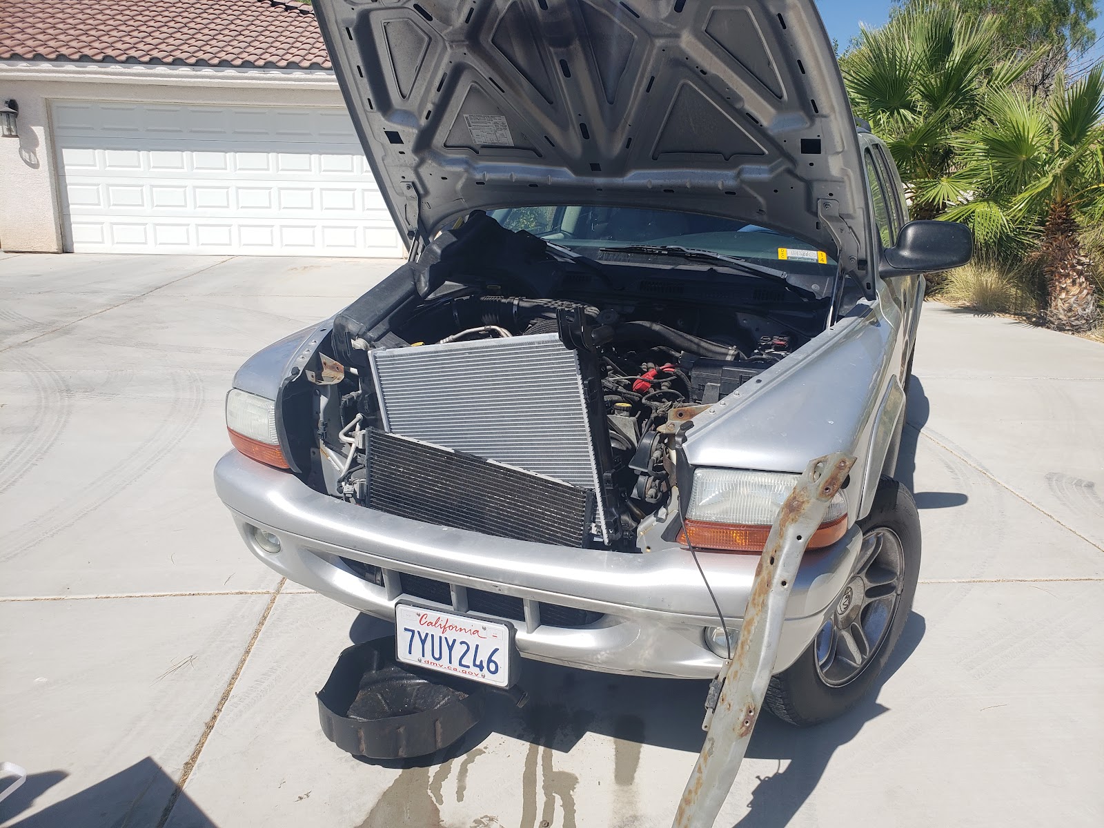 Dodge Durango with hood up and radiator/condenser pulled out for replacement in a driveway
