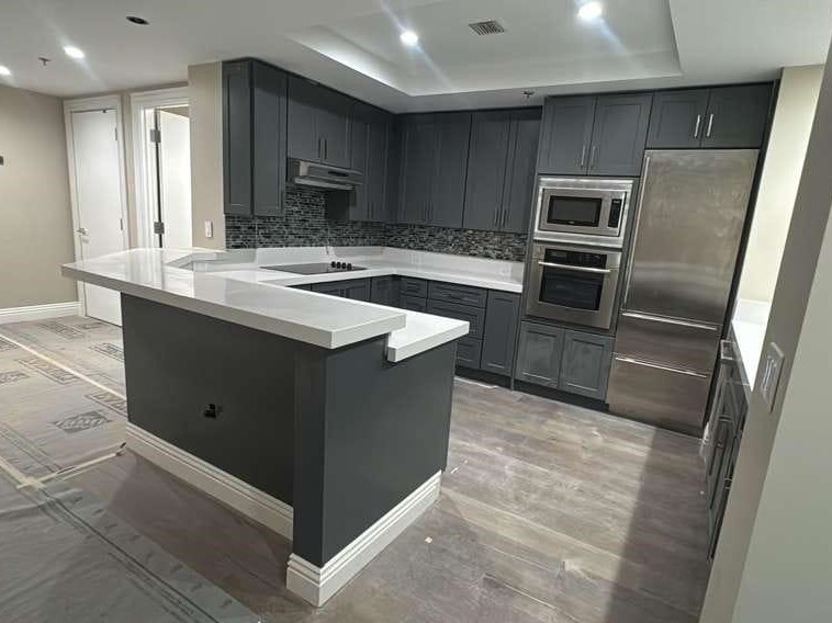 Gray shaker cabinet kitchen with white quartz counters and stainless appliances