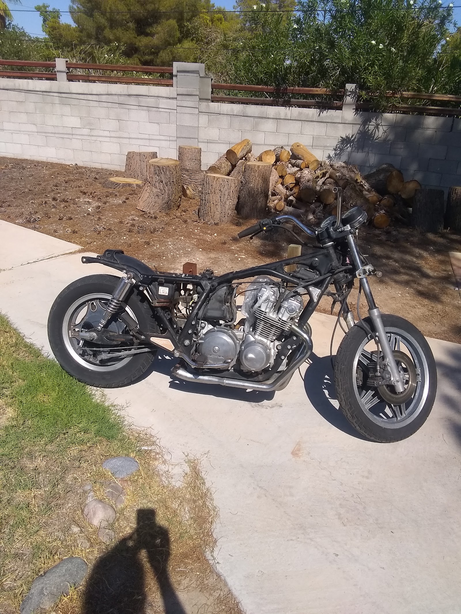 Stripped-down Honda motorcycle frame and engine in a driveway