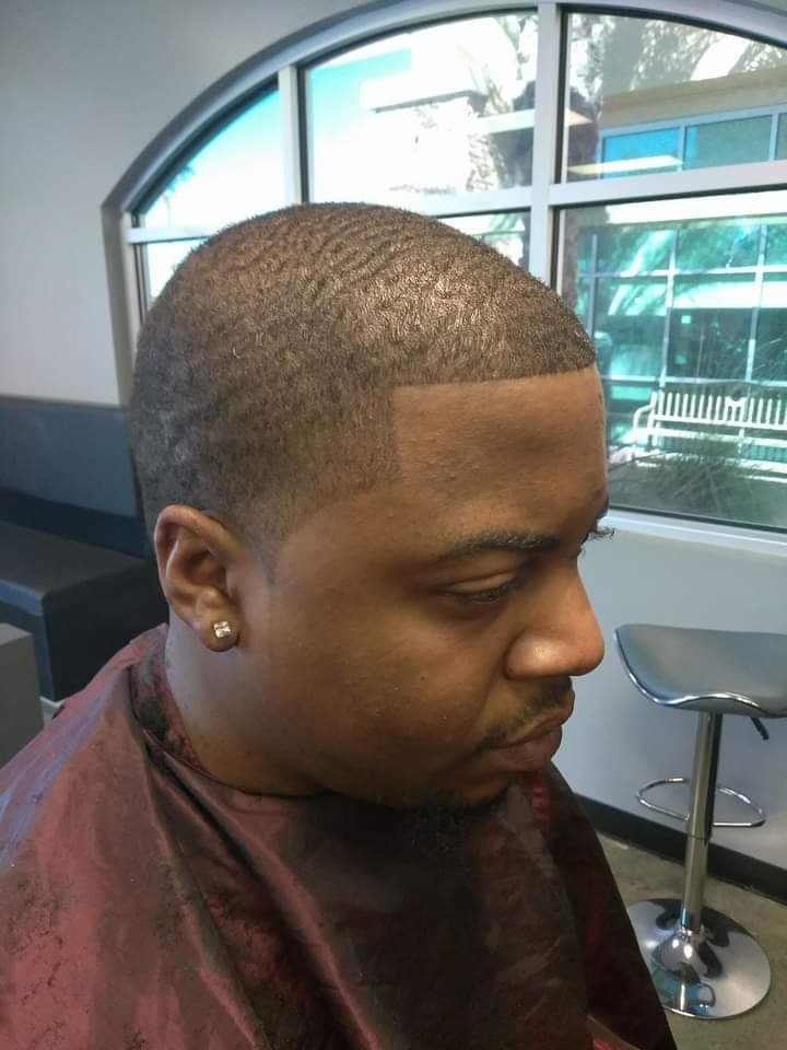 Man with waves and clean fade line-up in barber chair