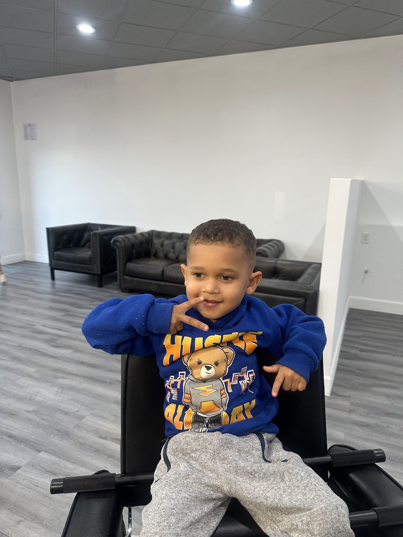 Young boy with fresh haircut posing in barber chair