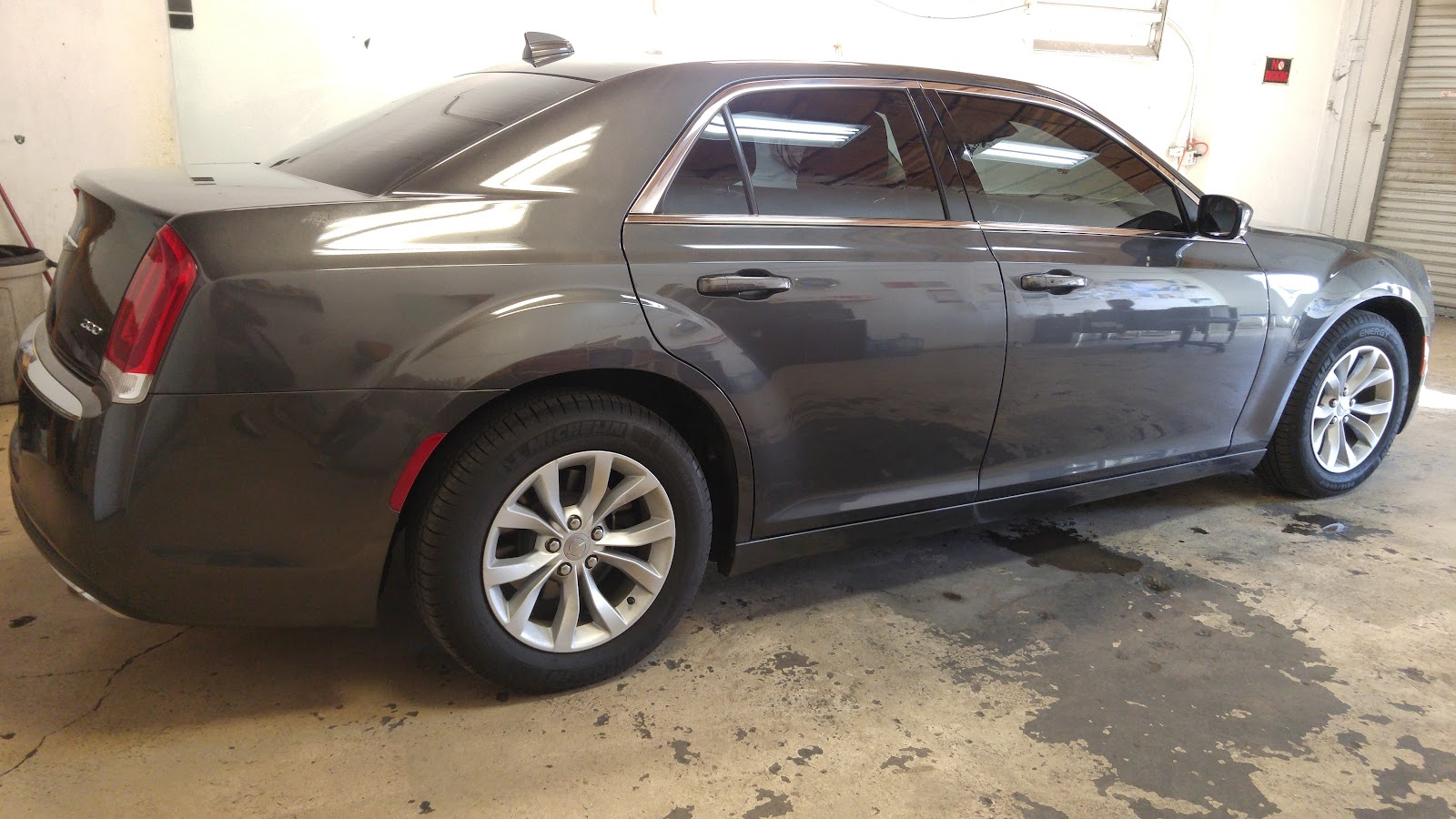 Gray Chrysler 300 rear three-quarter view with tinted windows in shop