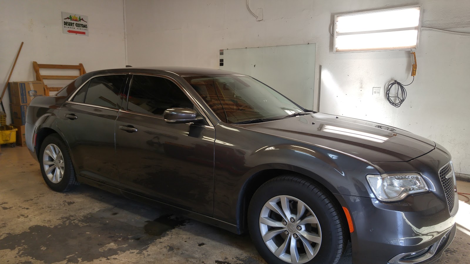 Gray Chrysler 300 with tinted windows inside Desert Customs tint shop