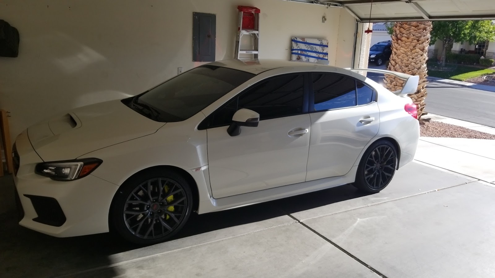 White Subaru WRX STI with tinted windows parked in a garage
