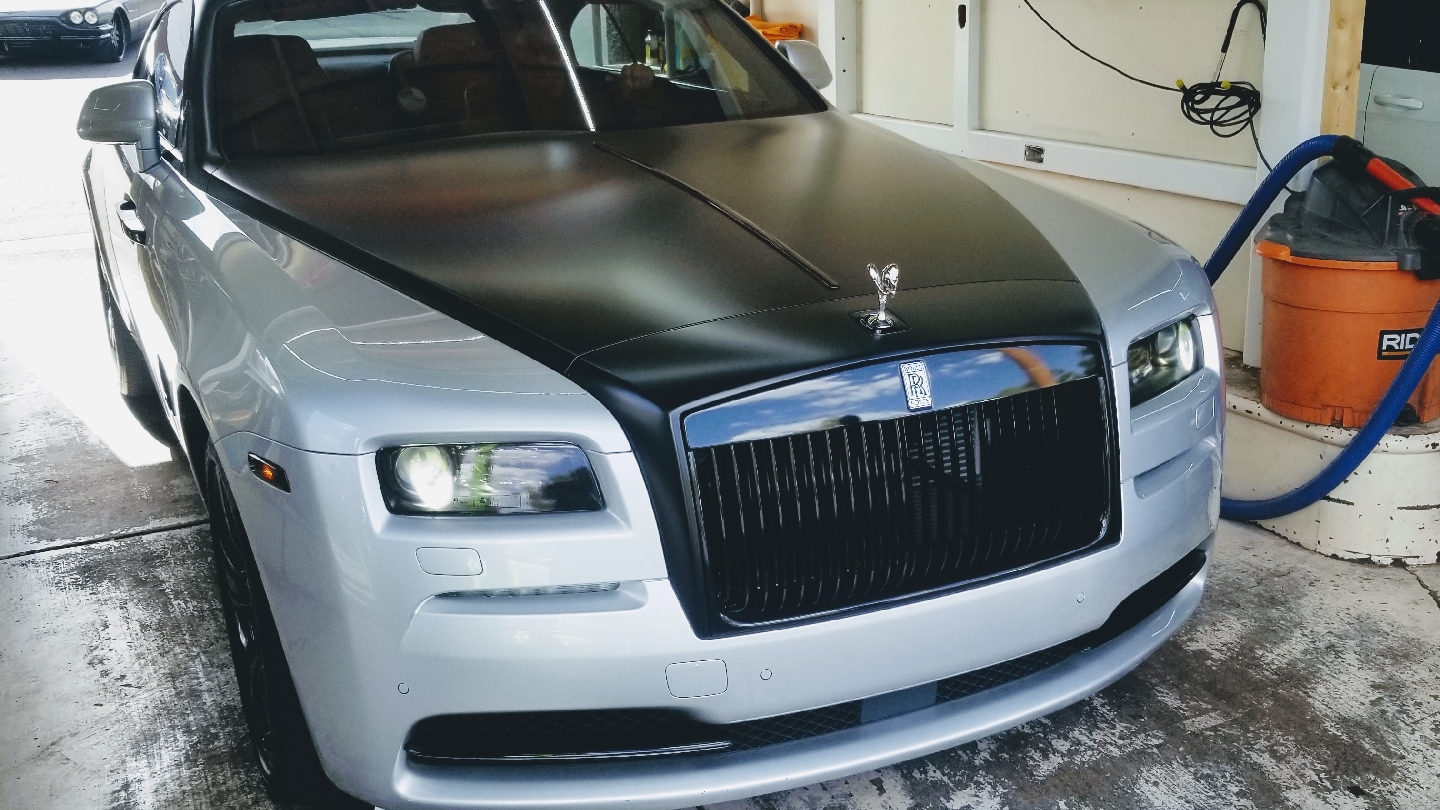 Silver Rolls-Royce Wraith with matte black hood wrap being detailed