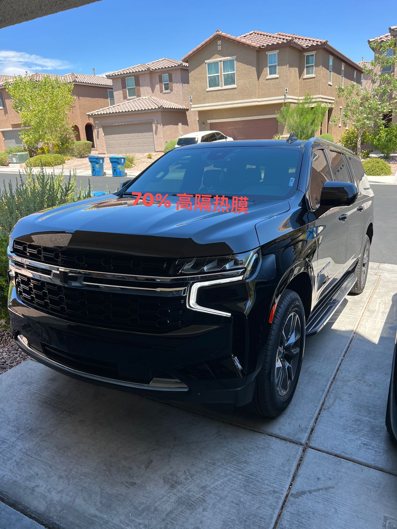 Black Chevrolet Suburban with tinted windows in a residential driveway