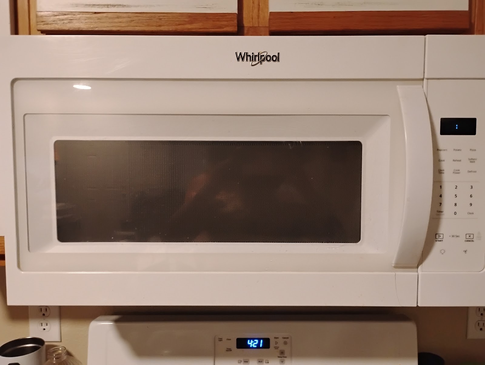 White Whirlpool over-the-range microwave above stove