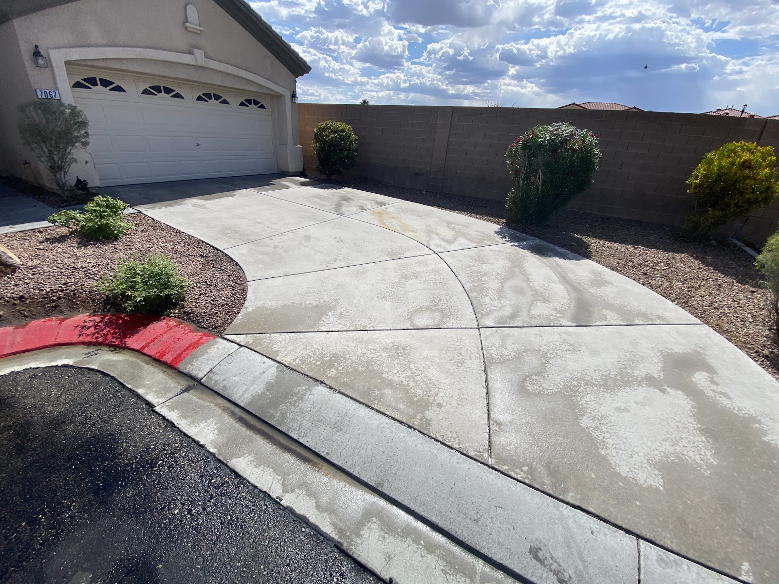 Residential concrete driveway partially cleaned showing before and after contrast