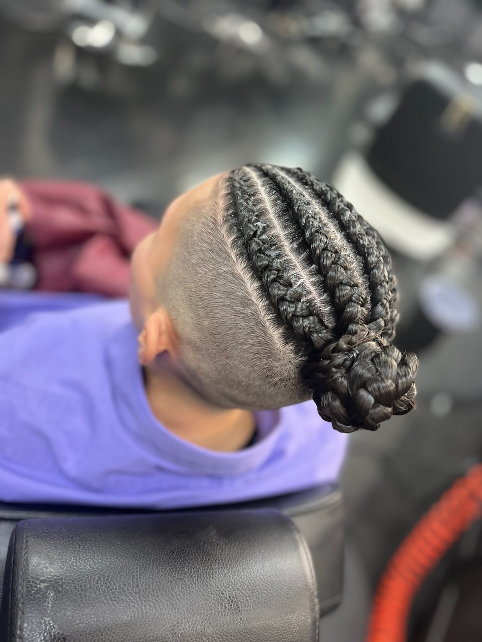 Braided cornrows into a bun with faded sides