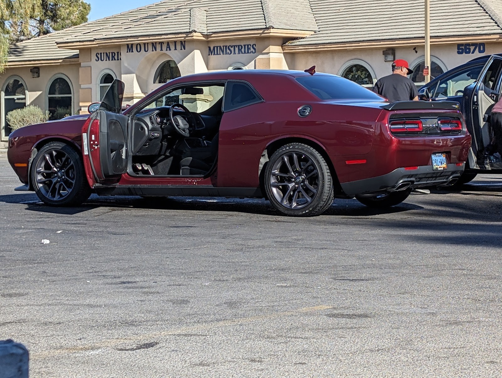 Clean maroon Dodge Challenger with doors open in parking lot