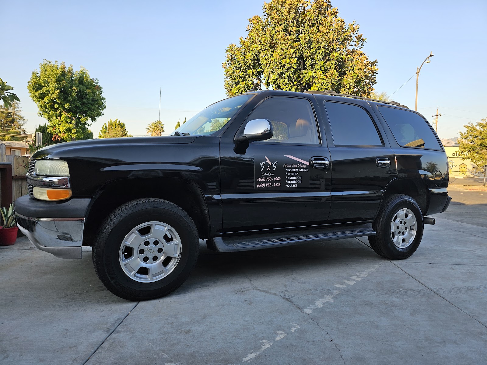 Clean black Chevrolet Tahoe with cleaning-company decal after wash