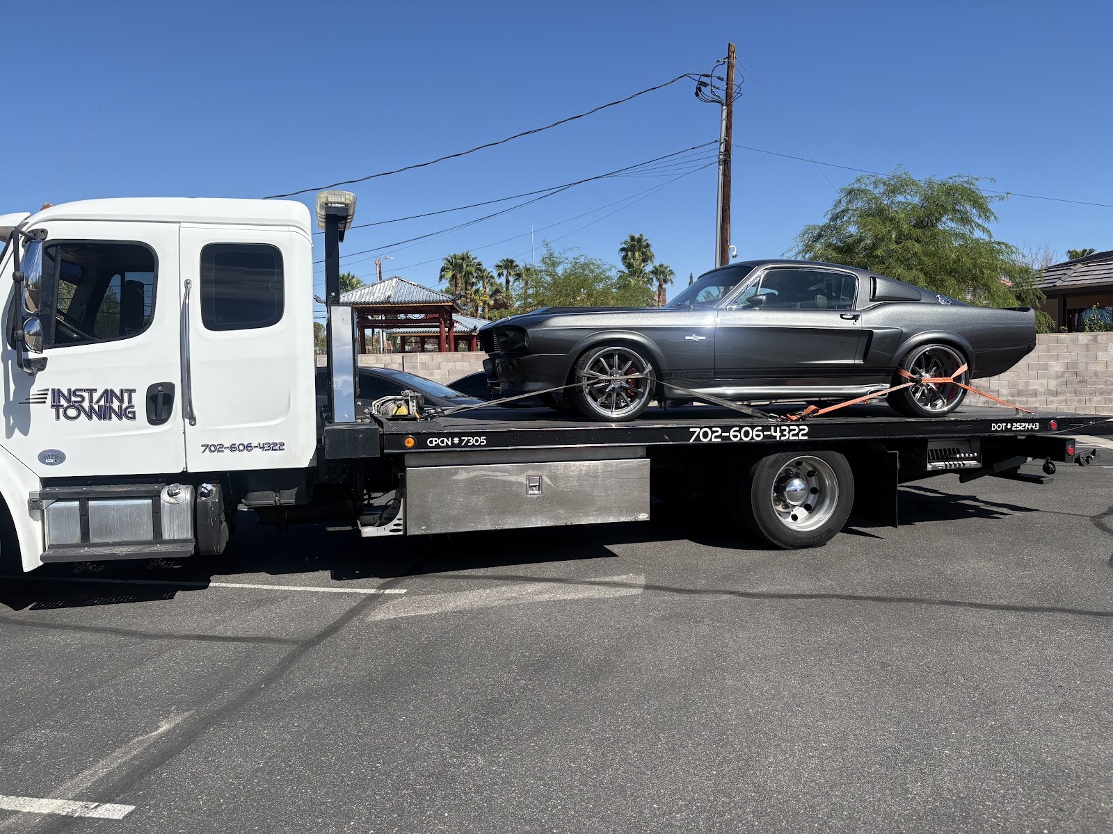 Instant Towing flatbed hauling a gray classic Ford Mustang fastback