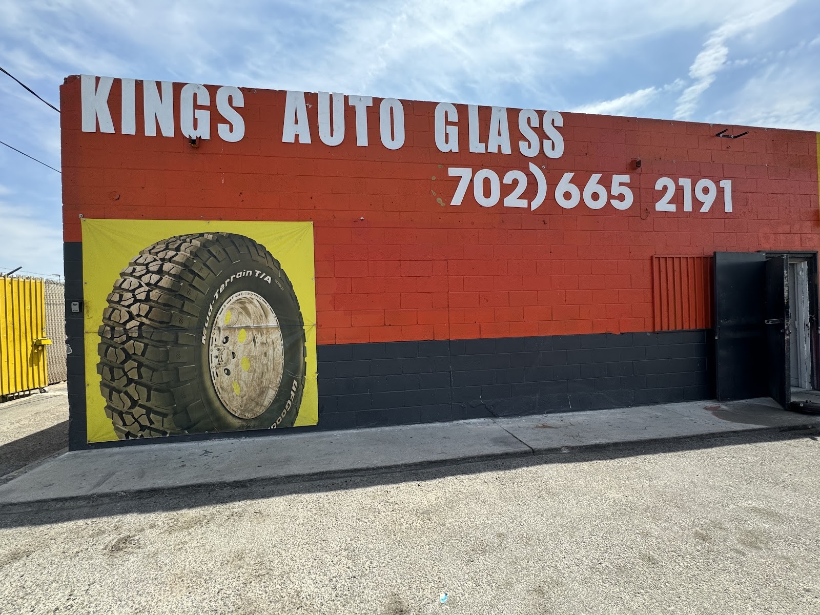 Kings Auto Glass building exterior with large tire mural and phone number