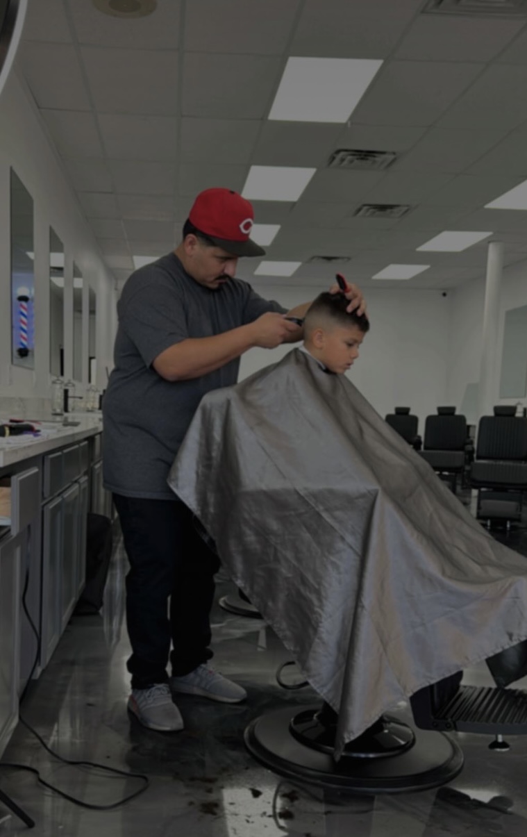 Barber cutting a young boy's hair in the shop
