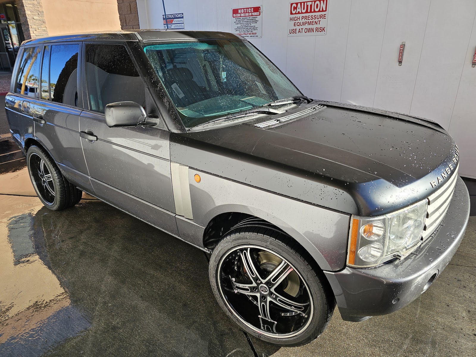 Clean wet Range Rover with beaded water at car wash bay