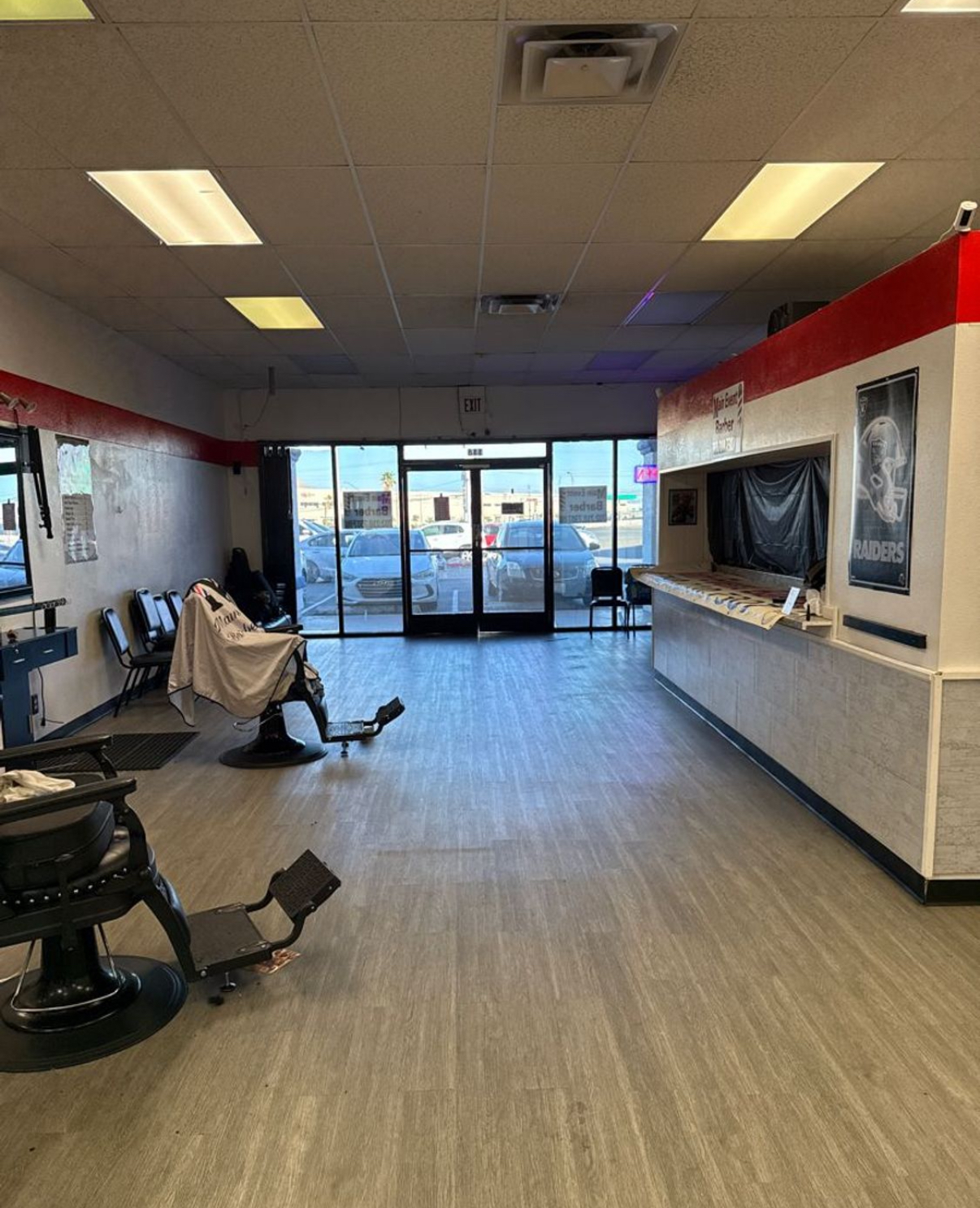 Barbershop interior with barber chairs, reception counter and Raiders poster