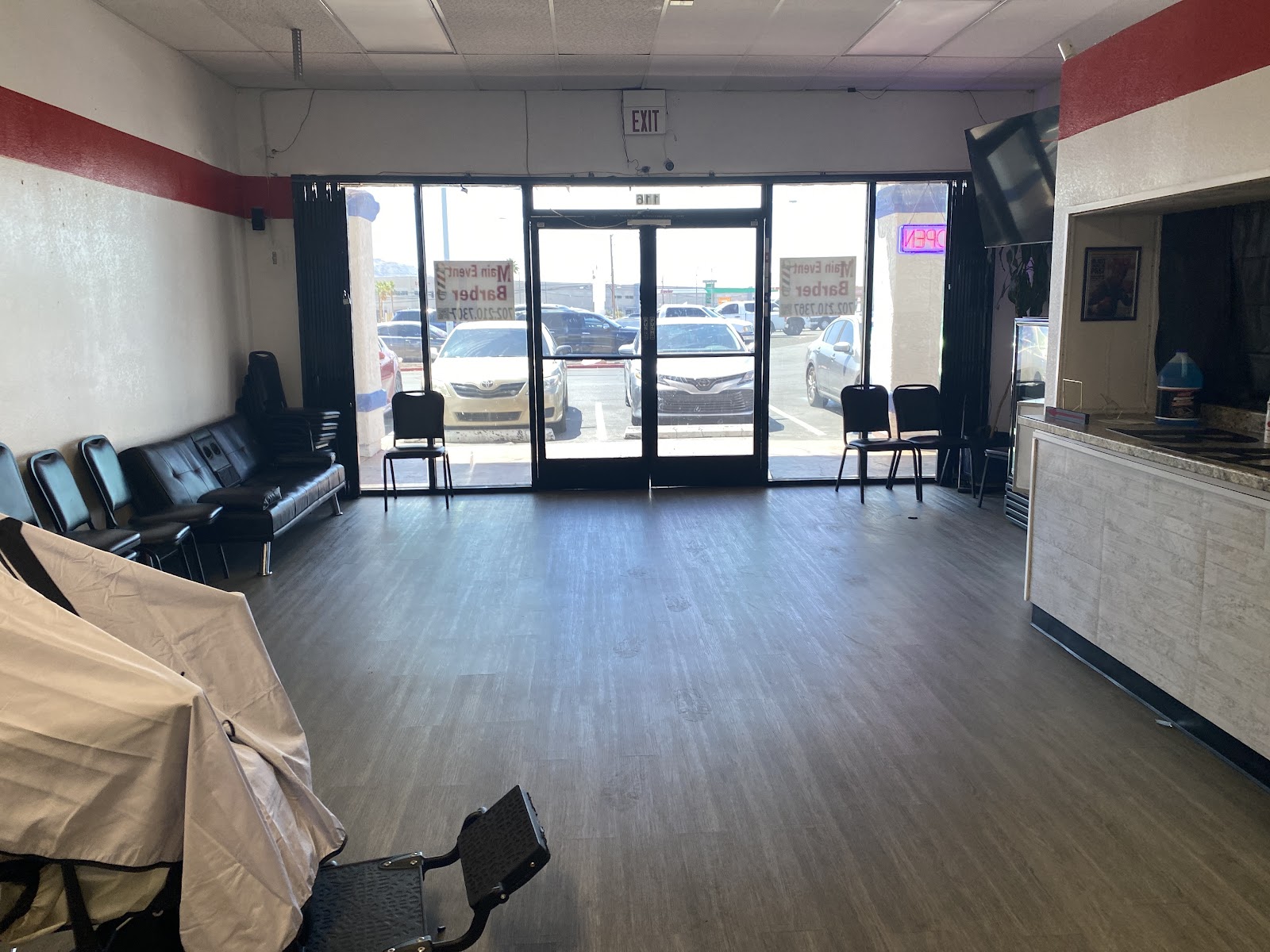 Interior of barbershop with waiting area seating and front entrance