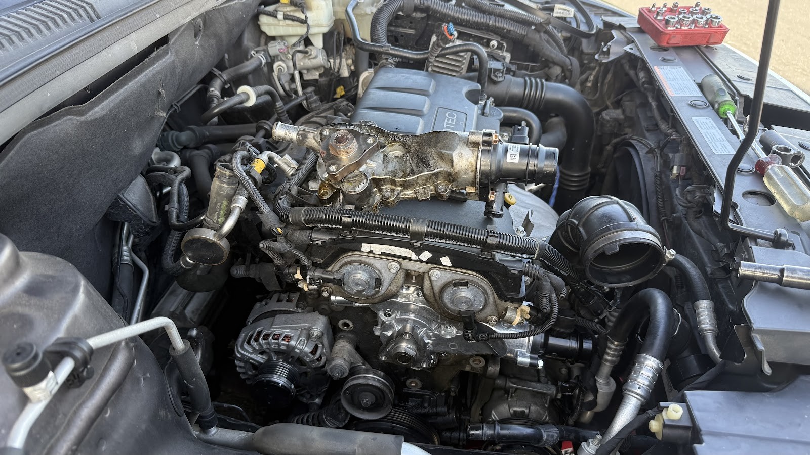 Engine bay of a truck with upper components removed during repair