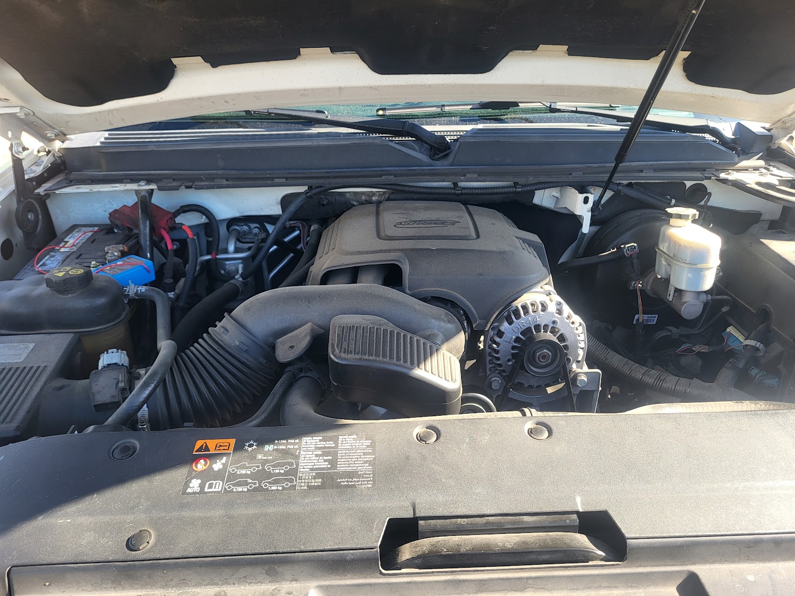 Open engine bay of a Chevrolet/GMC truck showing engine and alternator
