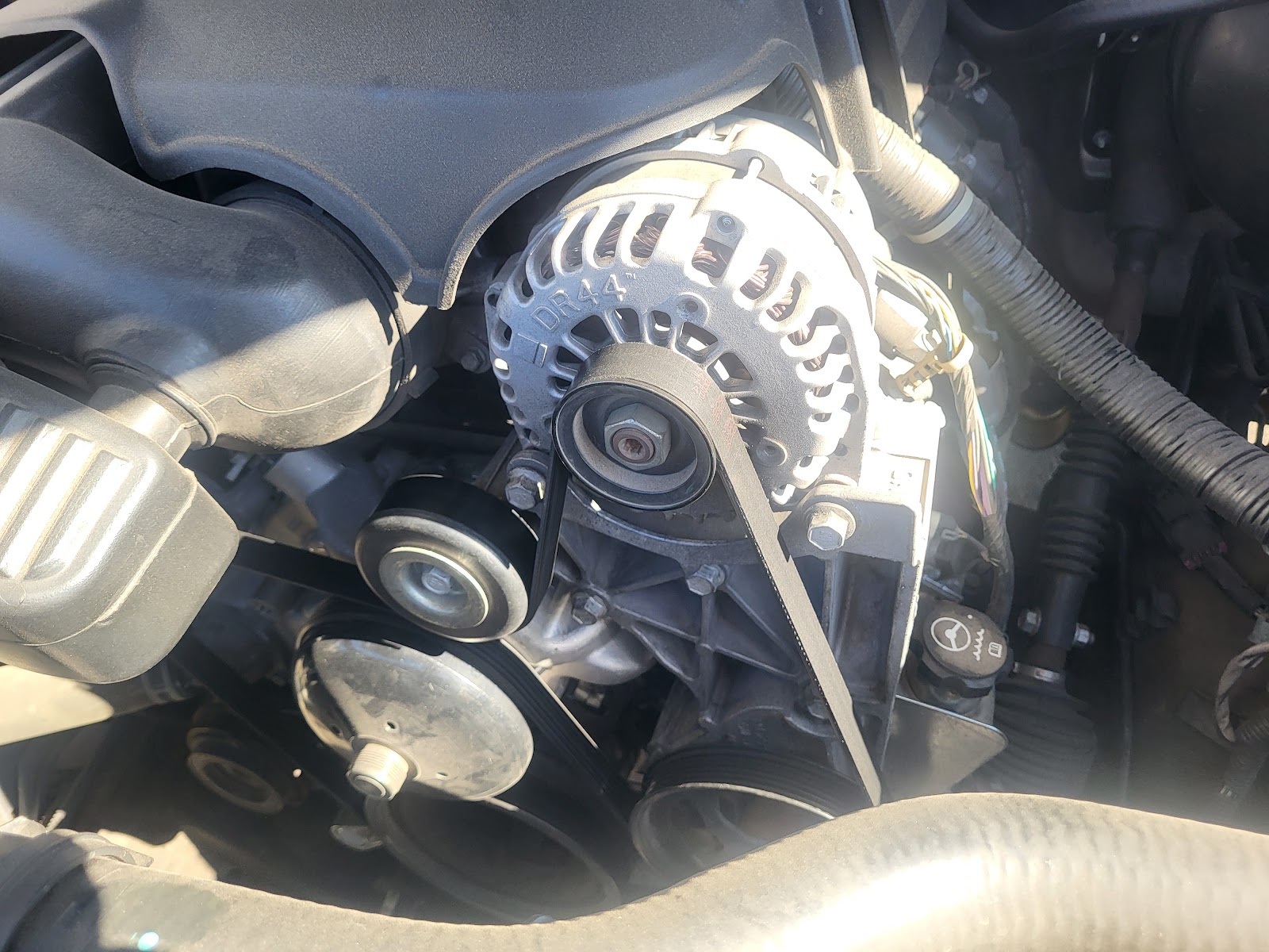 Close-up of DR44 alternator and serpentine belt in engine bay