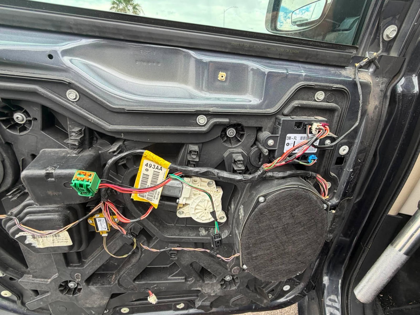Interior of car door panel removed showing window motor and wiring harness