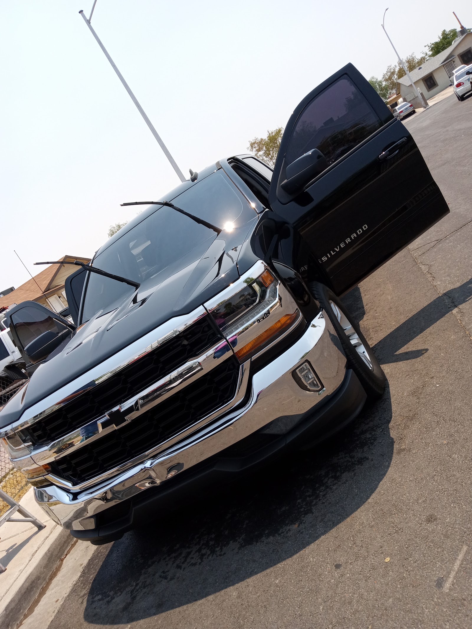 Freshly detailed dark Chevy Silverado with door open outdoors