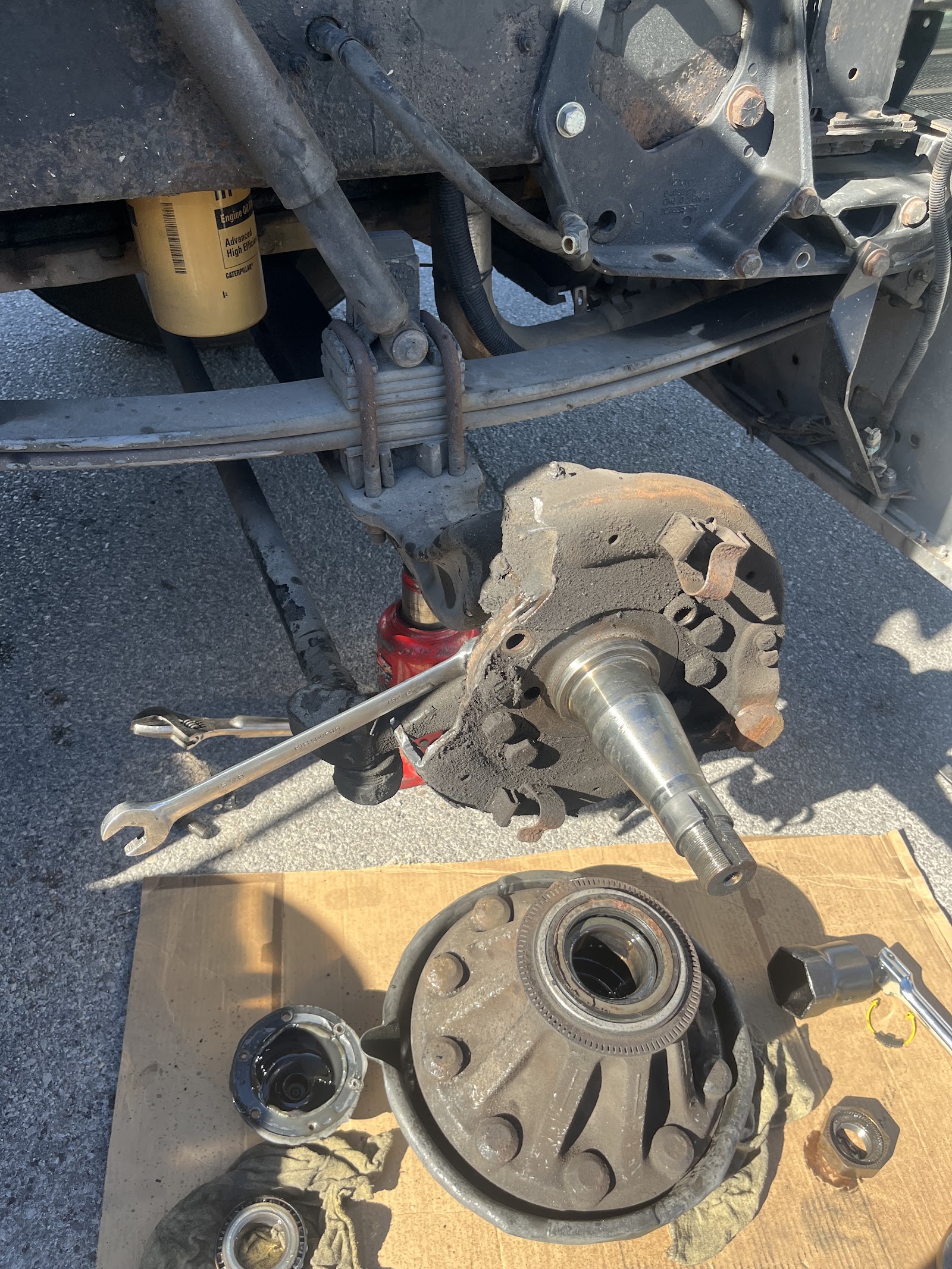 Truck front axle spindle, steering knuckle and wheel hub disassembled for bearing service
