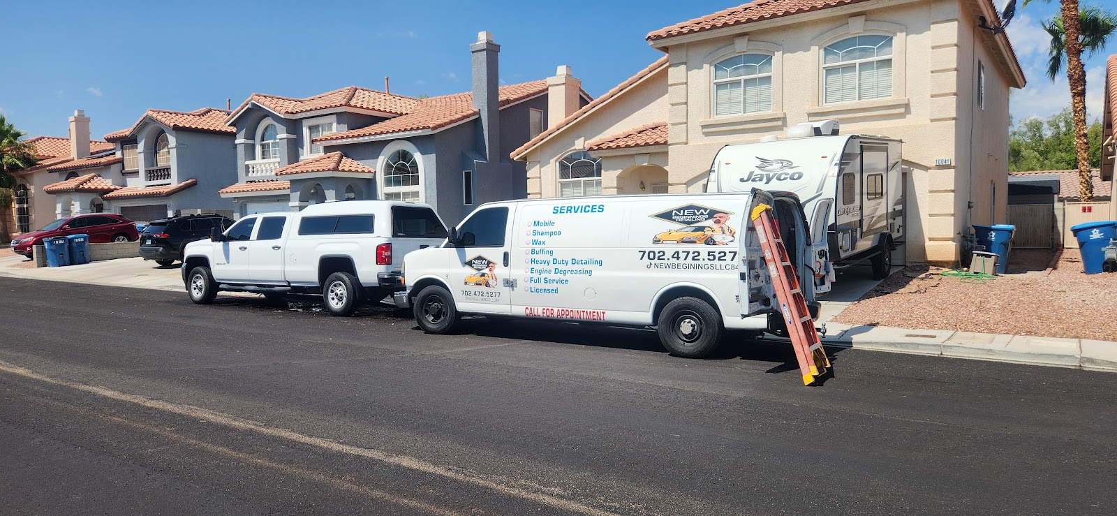 Branded New Beginnings Detailing van and truck parked in a residential neighborhood near an RV