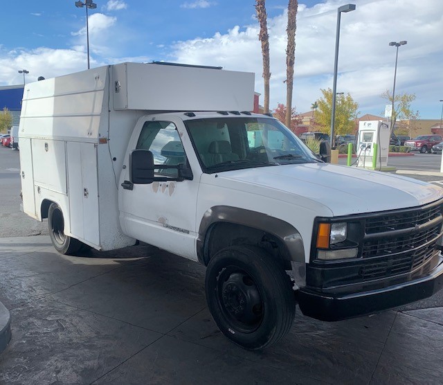 White Chevrolet utility service truck parked in a lot