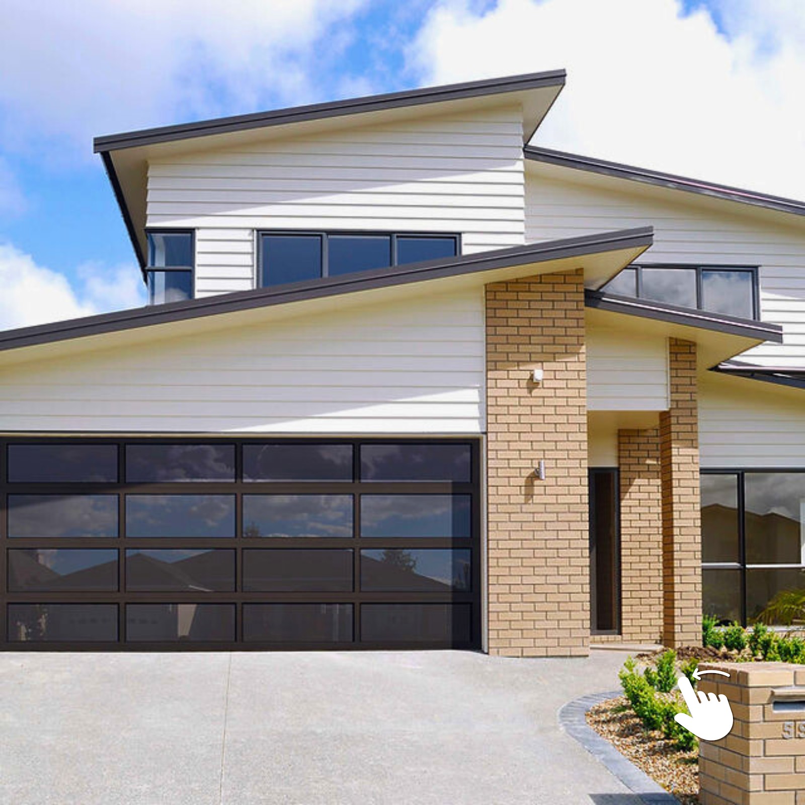 Contemporary home with dark glass-panel garage door and brick accents