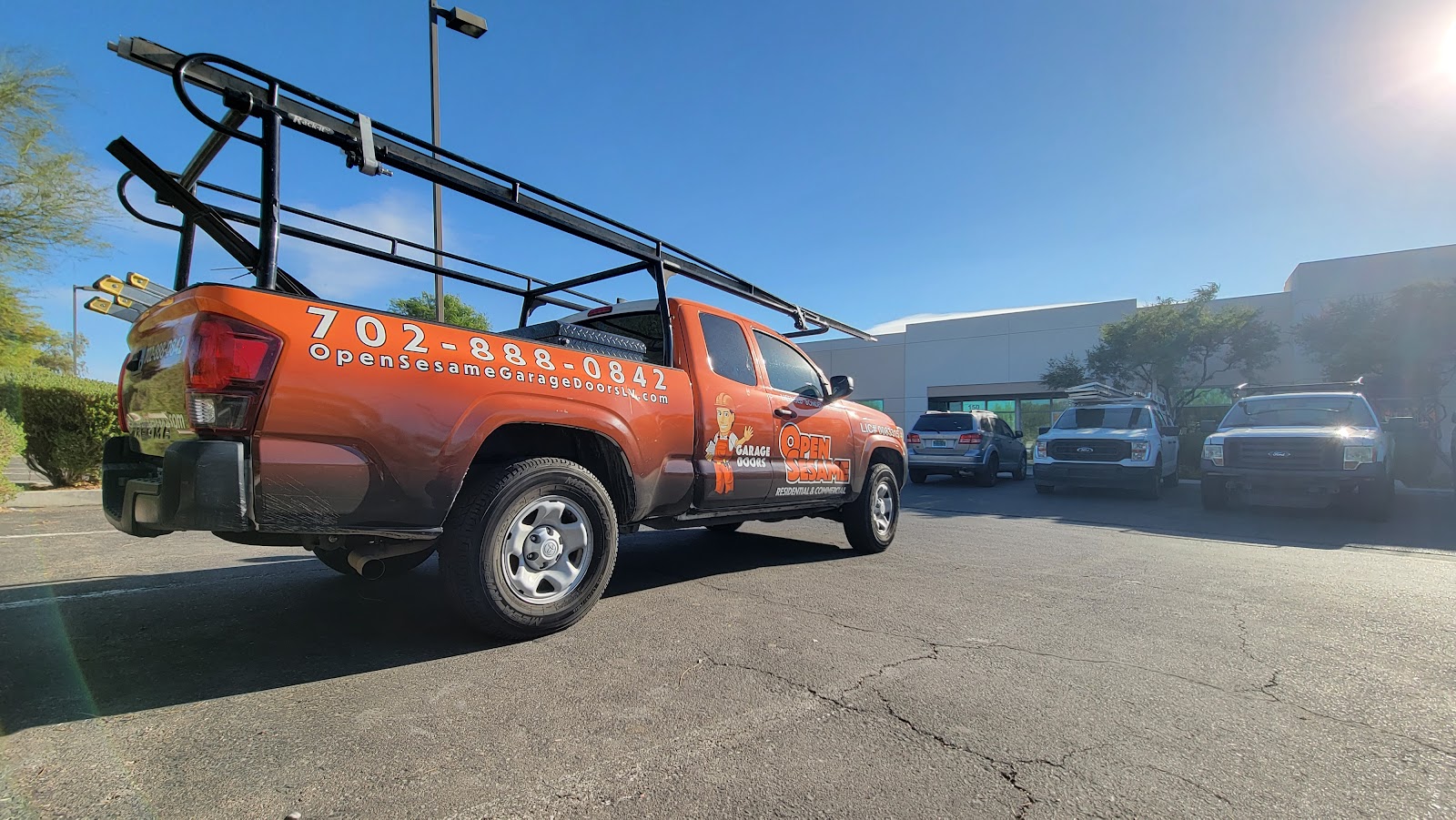 Orange Open Sesame Garage Doors branded Toyota Tacoma work truck in parking lot