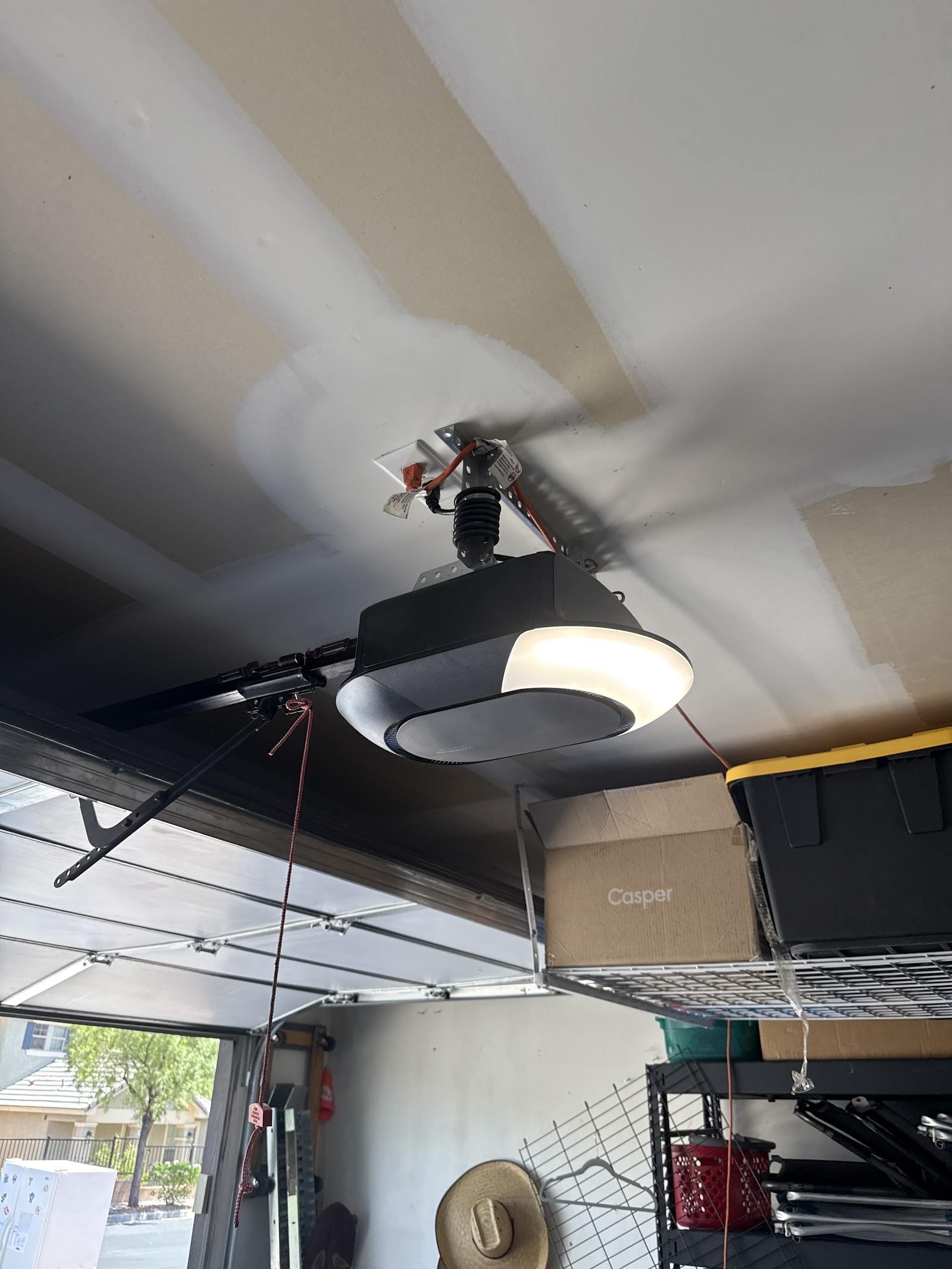 Installed garage door opener with light mounted to ceiling in a home garage