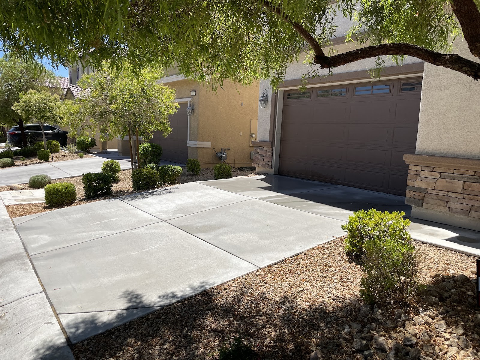 Clean residential driveway in front of home with brown garage door