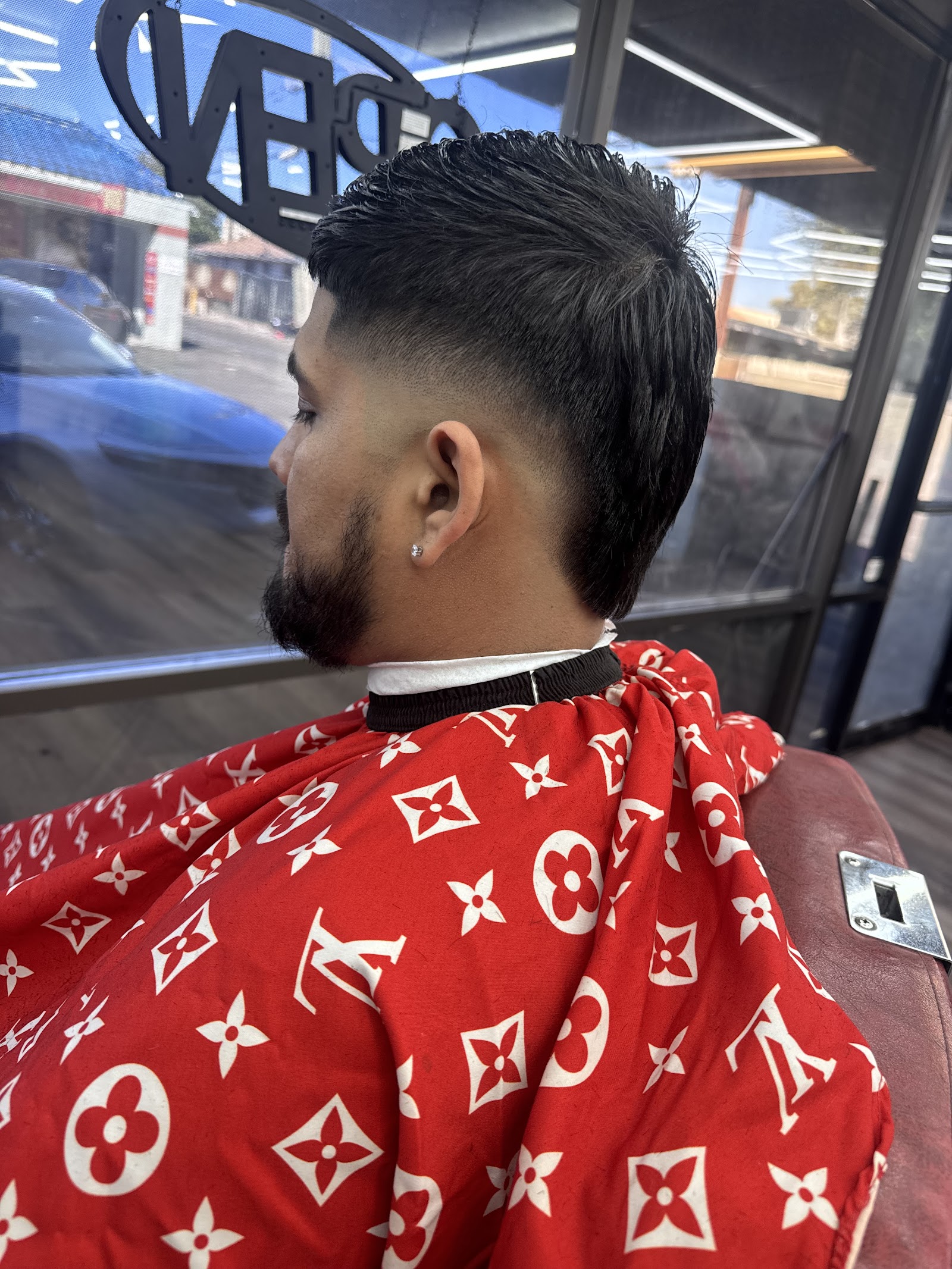 Back-side view of men's textured haircut with taper fade and beard
