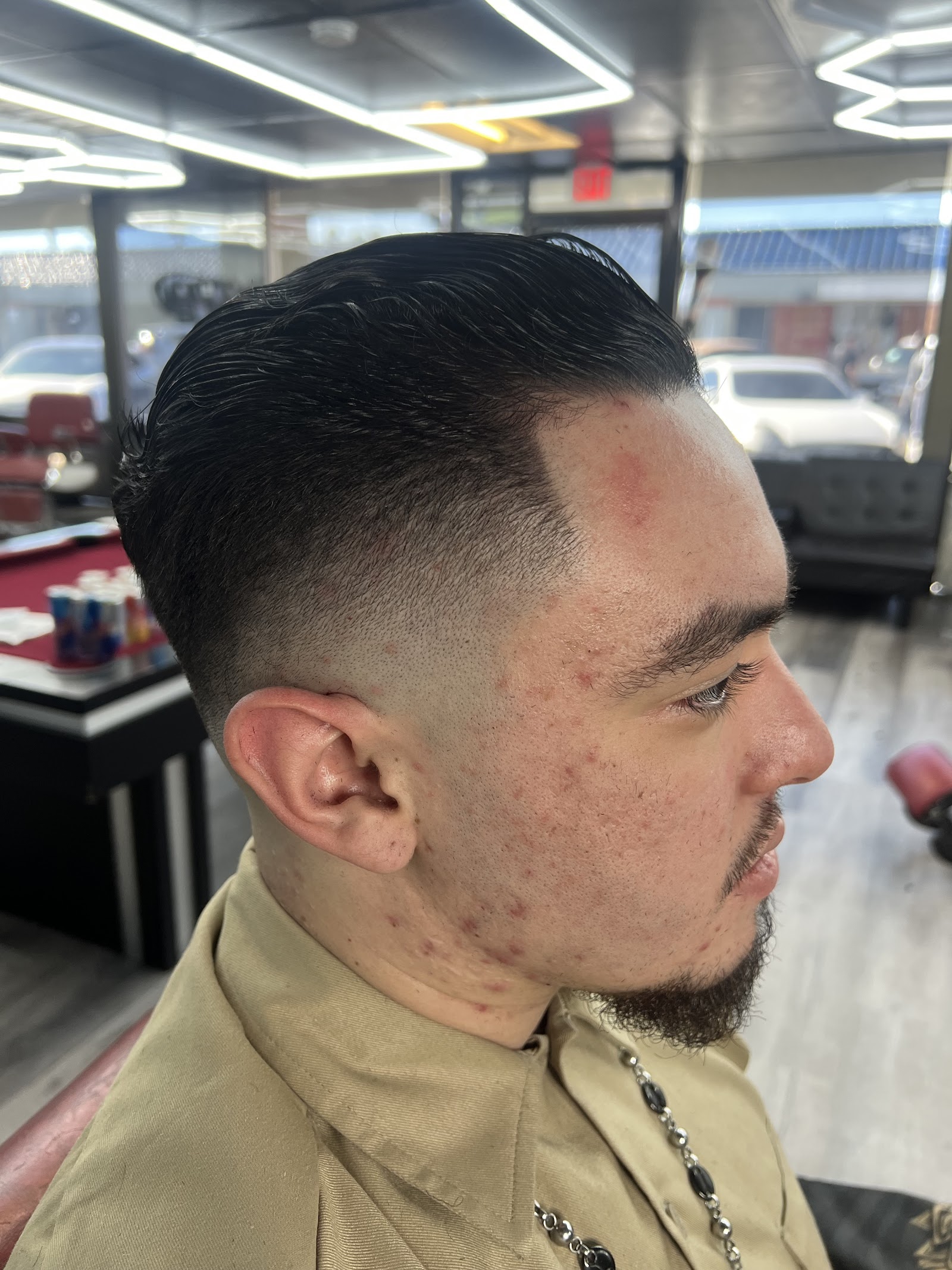 Side profile of men's slicked-back haircut with skin fade