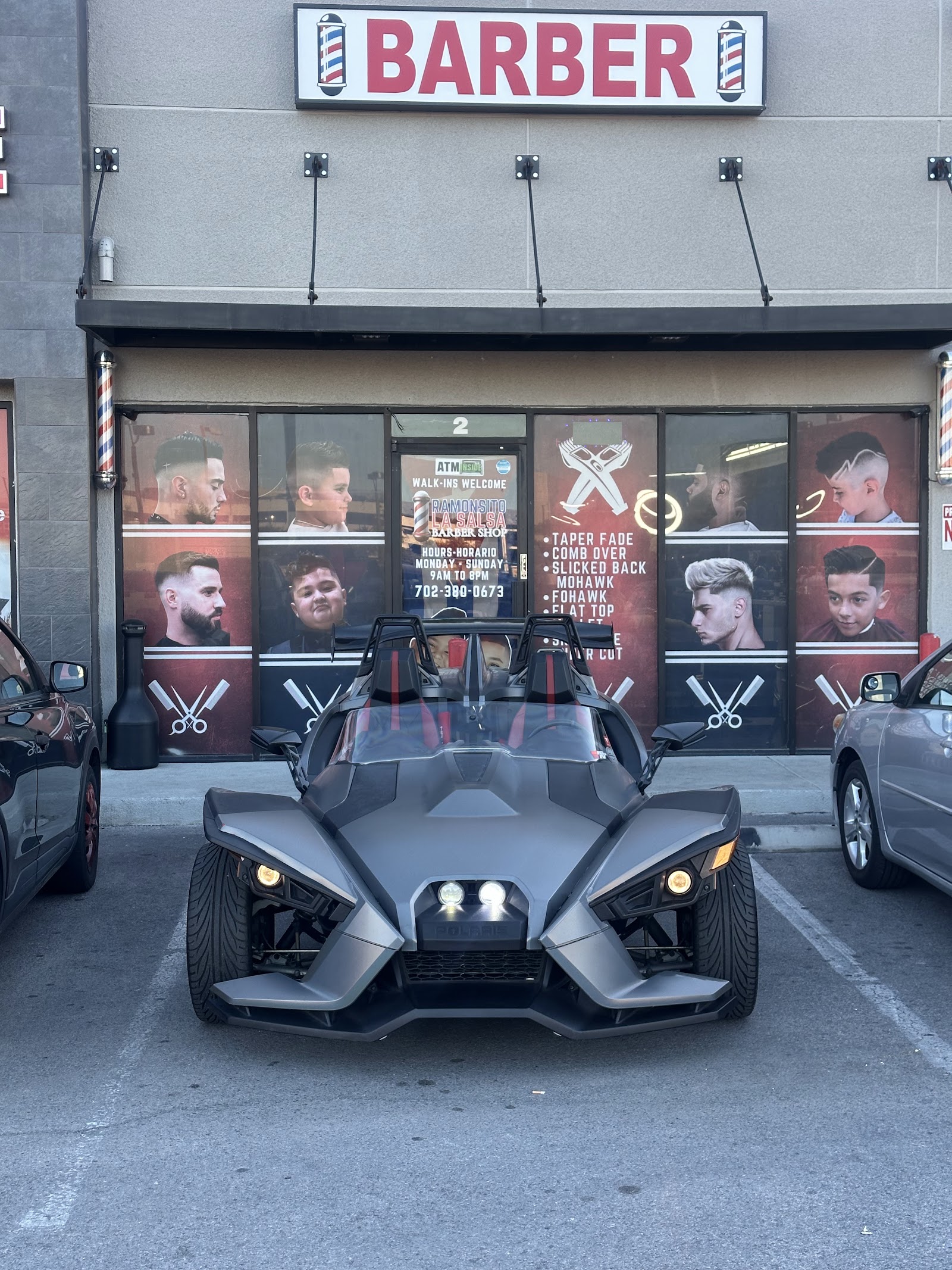 Polaris Slingshot parked in front of the barber shop storefront