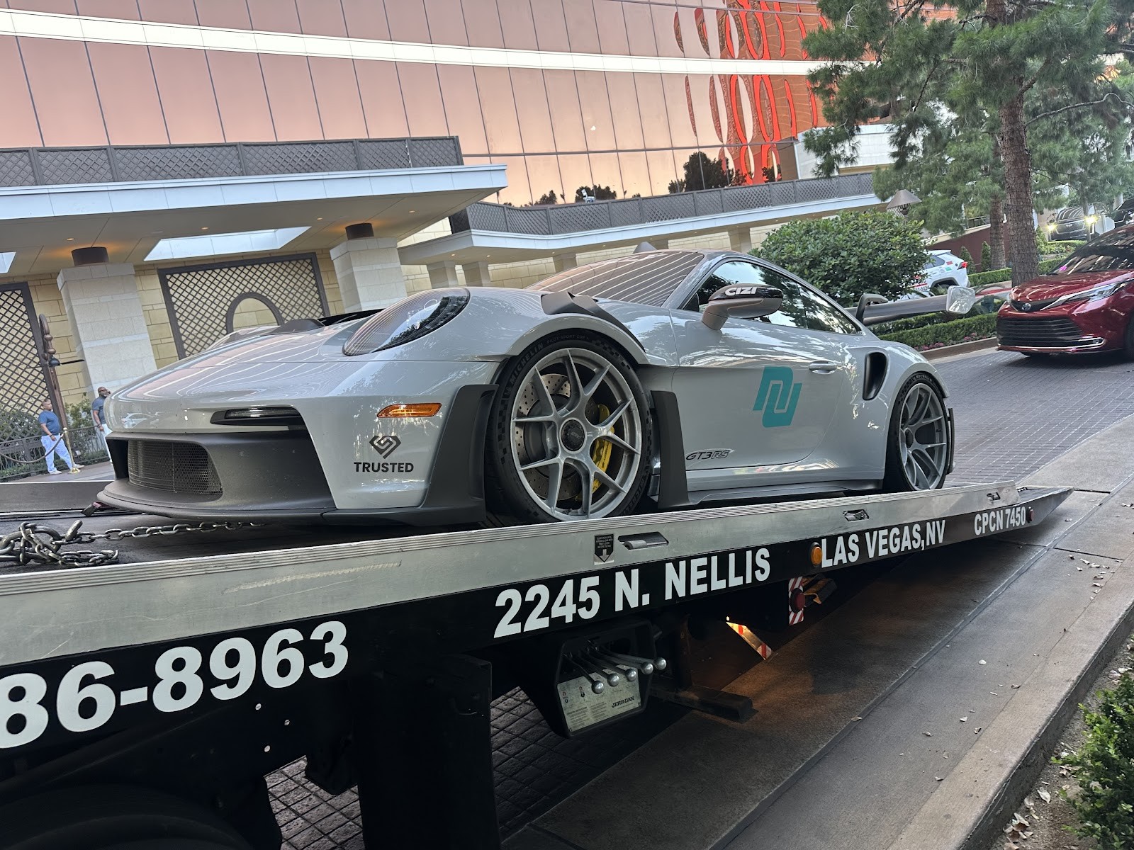 Silver Porsche 911 GT3 RS on a Reggie's Towing flatbed outside a Las Vegas resort